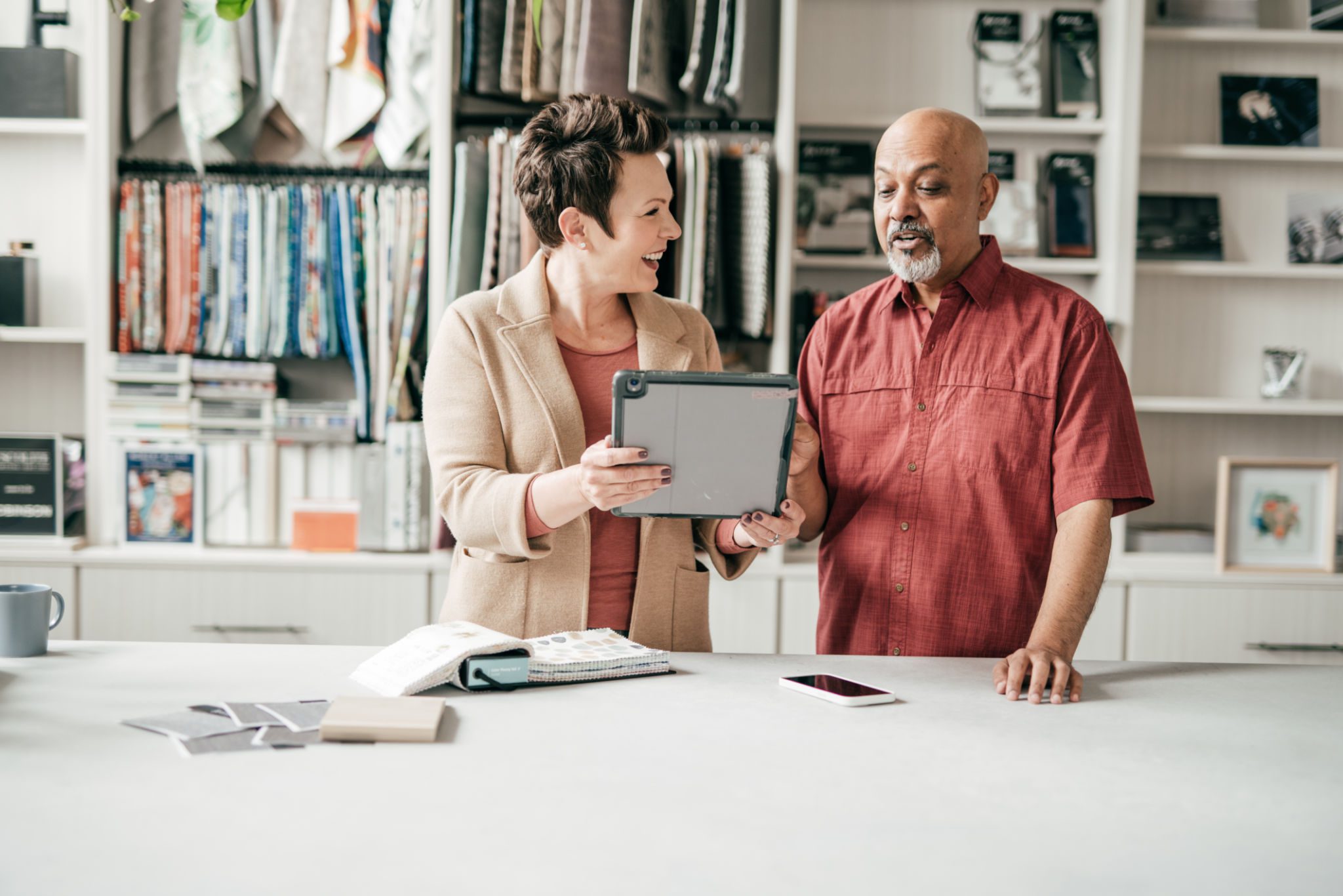 Two colleagues discussing work with a tablet in a creative studio.