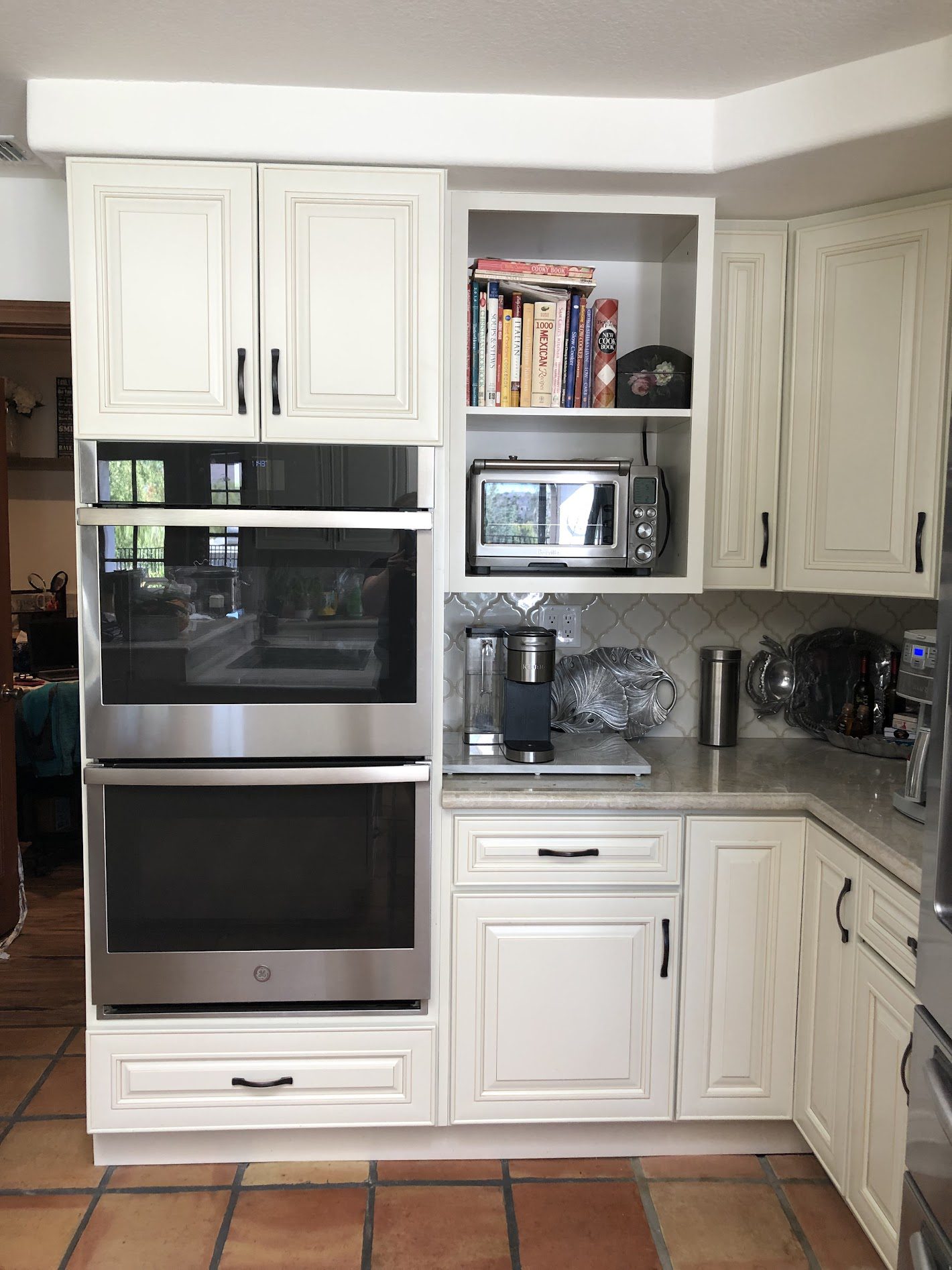 Modern kitchen with white cabinetry and built-in appliances.